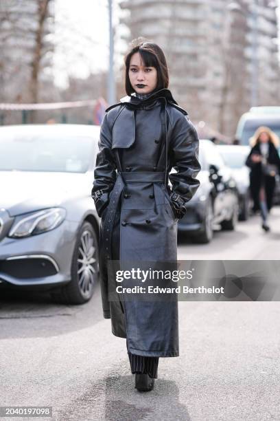 Guest wears a black long leather trench coat, outside Ferragamo, during the Milan Fashion Week - Womenswear Fall/Winter 2024-2025 on February 24,...