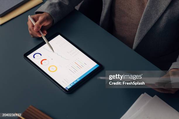 professional analyzing financial data on tablet with stylus pen - digitizer-pen-tablet stock pictures, royalty-free photos & images