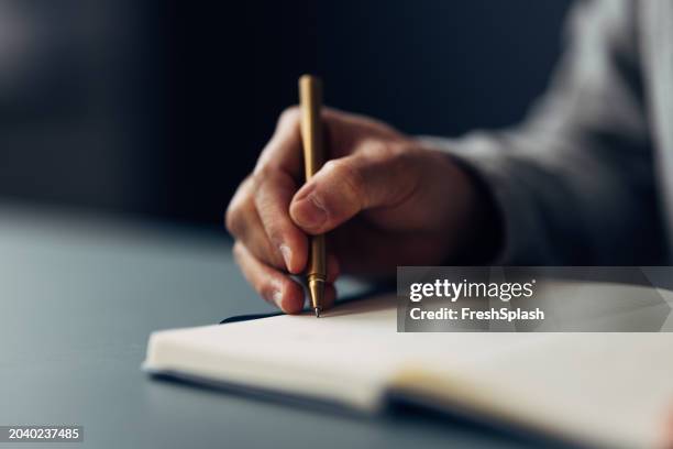 close-up of hand writing in notebook with luxury pen, focus on writing - luxury fountain pen stock pictures, royalty-free photos & images