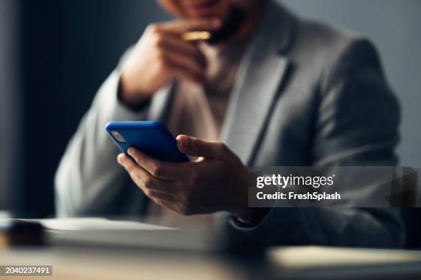 geschäftsmann wertet informationen auf dem smartphone im büro aus - blauer anzug stock-fotos und bilder