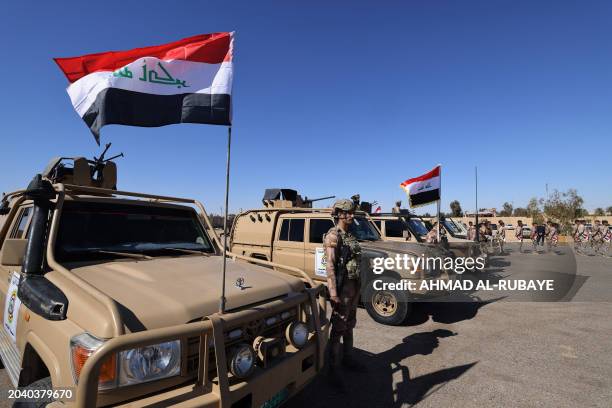 Iraqi soldiers from the new 'desert battalion' special forces stand next to military vehicles as the take part in a graduation ceremony, after months...