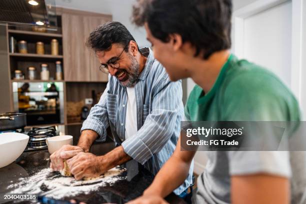 father and son cooking together at home - family baking bread stock pictures, royalty-free photos & images
