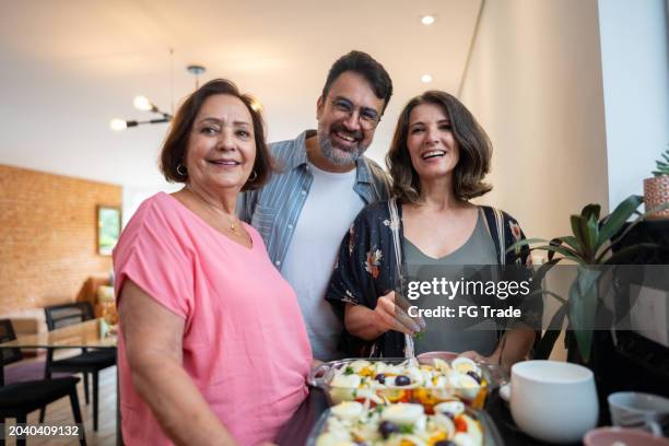 portrait of family cooking together at home - son in law stock pictures, royalty-free photos & images