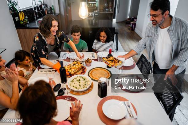 family having lunch together at home - fish dinner stock pictures, royalty-free photos & images