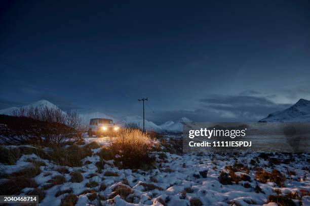 4x4 car with lights on in with snow covered landscape. - vehicle light stock pictures, royalty-free photos & images