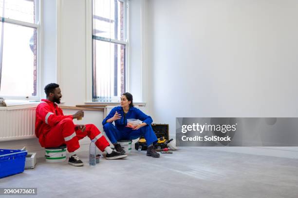 blue collar workers on lunch break - overall stockfoto's en -beelden
