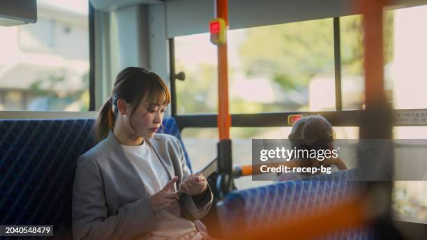 businesswoman commuting by bus with her small daughter - city life authentic stock pictures, royalty-free photos & images