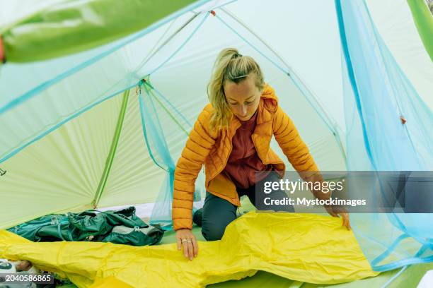 woman camping inflating mattress - mat stock pictures, royalty-free photos & images