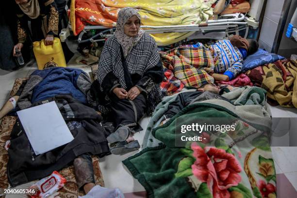 Woman sits among Palestinians at Al-Shifa hospital in Gaza City after they were injured in an early morning incident when residents rushed toward aid...