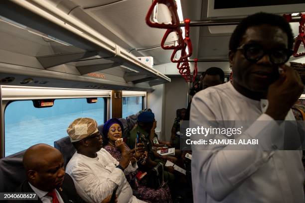 Guest applies some make up as she sits with and dignitaries onboard the the Red Line Train at the Ikeja train station during its inaguration by the...