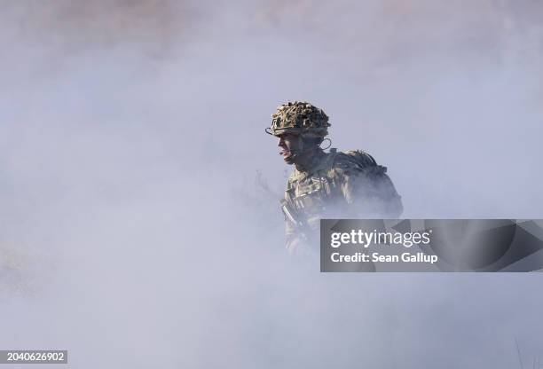 Soldier of the United Kingdom's 2nd Battalion Royal Anglian infantry unit runs through smoke as he storms an enemy position in a simulated attack...