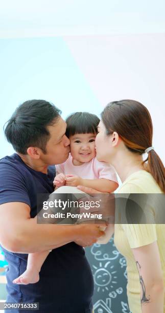 asian parent kiss little girl - accompanying stock pictures, royalty-free photos & images