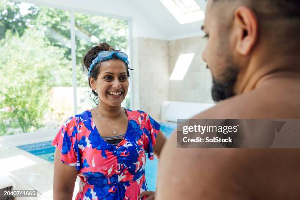 happy wife chatting to her husband - mid adult women stock pictures, royalty-free photos & images