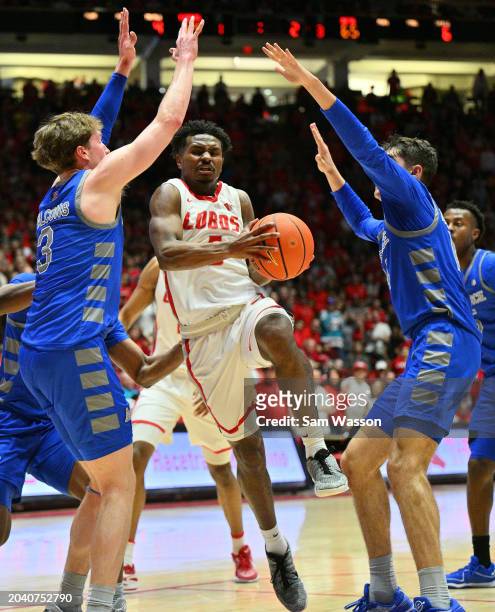 Jamal Mashburn Jr. #5 of the New Mexico Lobos drive between Luke Kearney and Beau Becker of the Air Force Falcons during the second half at The Pit...