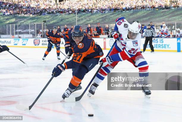 Chris Kreider of the New York Rangers checks Anders Lee of the New York Islanders during the 2004 Navy Federal Credit Union Stadium Series game at...