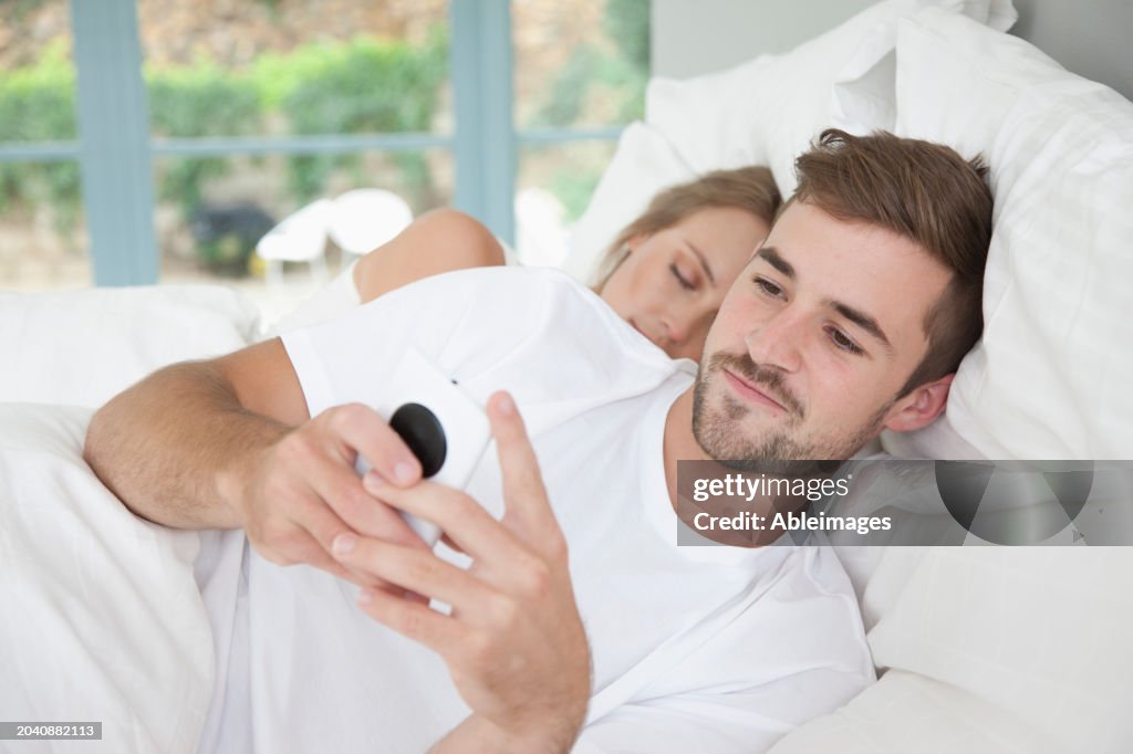 Man in Bed Using Smartphone