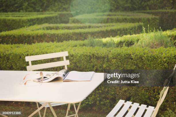 magazine and sunglasses on table in garden - magazine table ストックフォトと画像