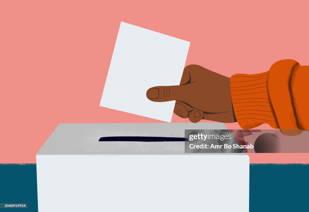 Close up hand of voter placing ballot in ballot box
