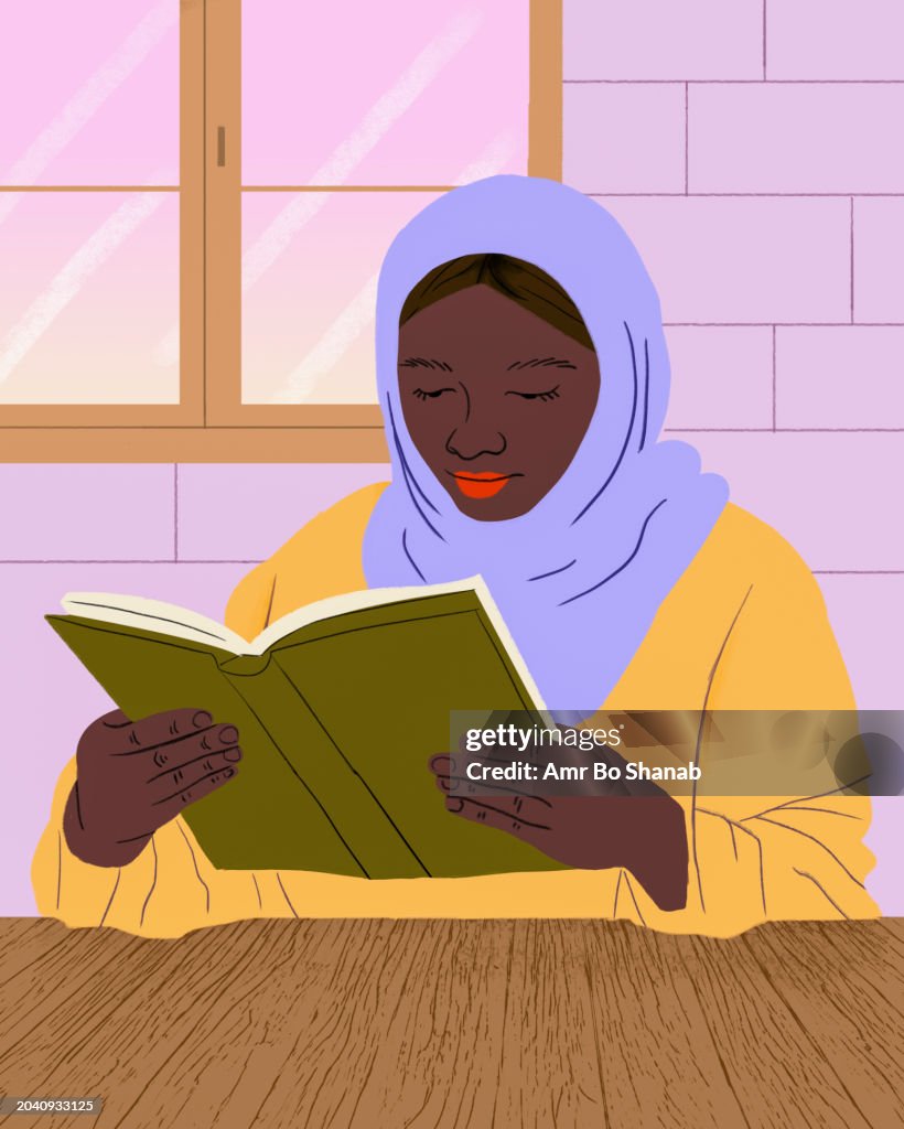 Muslim woman in hijab reading book at table