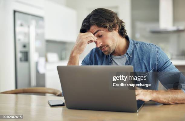 stressed, tired and overworked male entrepreneur with debt issues at home. young frustrated caucasian man unhappy about an email on his laptop and feeling sad, depressed and anxious in his house - missnöjd bildbanksfoton och bilder