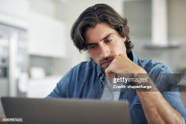 serious, thinking and stressed man reading on laptop while working at home. frustrated and upset man doing research on internet, checking email or waiting for online loan or job application answer - uncertainty stock pictures, royalty-free photos & images