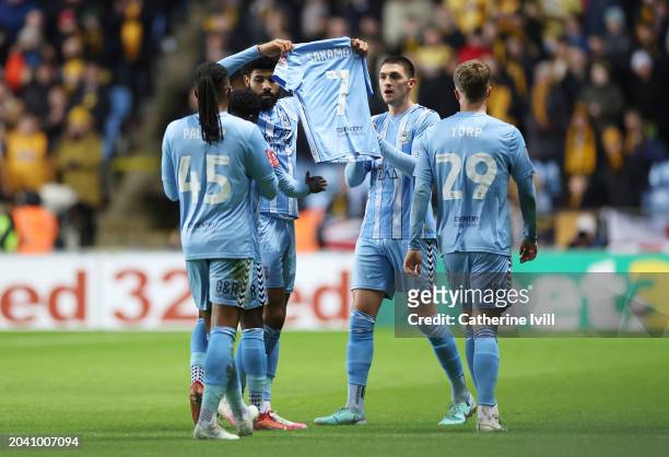 Ellis Simms of Coventry City celebrates scoring his team's first goal whilst holding the shirtt of injured team mate Tatsuhiro Sakamoto during the...