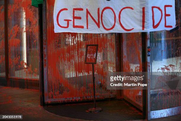 Protesters hang a banner saying 'Genocide' from the roof of the revolving doors on February 29, 2024 in Manchester, England. Palestine Action...