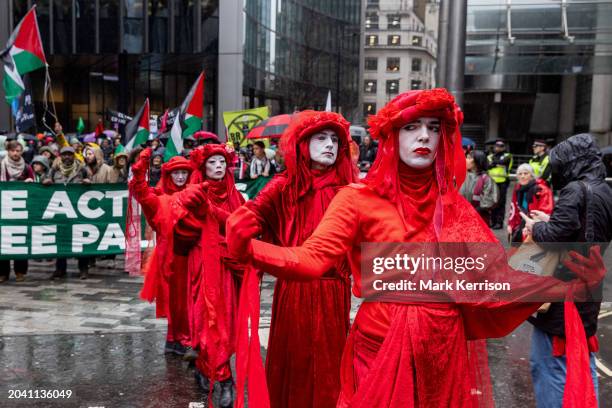 Extinction Rebellion's Red Rebels join climate and human rights activists marching to the offices of AXA UK plc to protest against the insurer's...