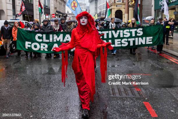 Extinction Rebellion's Red Rebels join climate and human rights activists marching to the offices of AXA UK plc to protest against the insurer's...