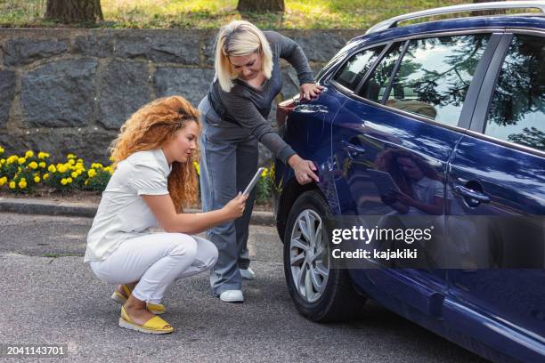 ajustador de reclamos ayudando a un conductor desafortunado - seguro de automóvil fotografías e imágenes de stock