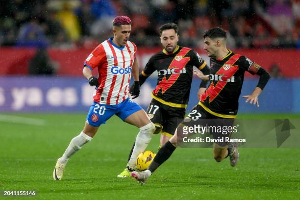 Yan Couto of Girona battles for the ball with Unai López of Rayo Vallecano and his team mate Óscar Valentín during the LaLiga EA Sports match between...
