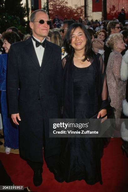 Actor Woody Harrelson with partner Laura Louie on the red carpet at the 69th Annual Academy Awards, Los Angeles, US, 24th March 1997 .