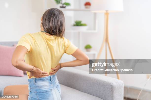young woman stretching her back - inflammation stock pictures, royalty-free photos & images