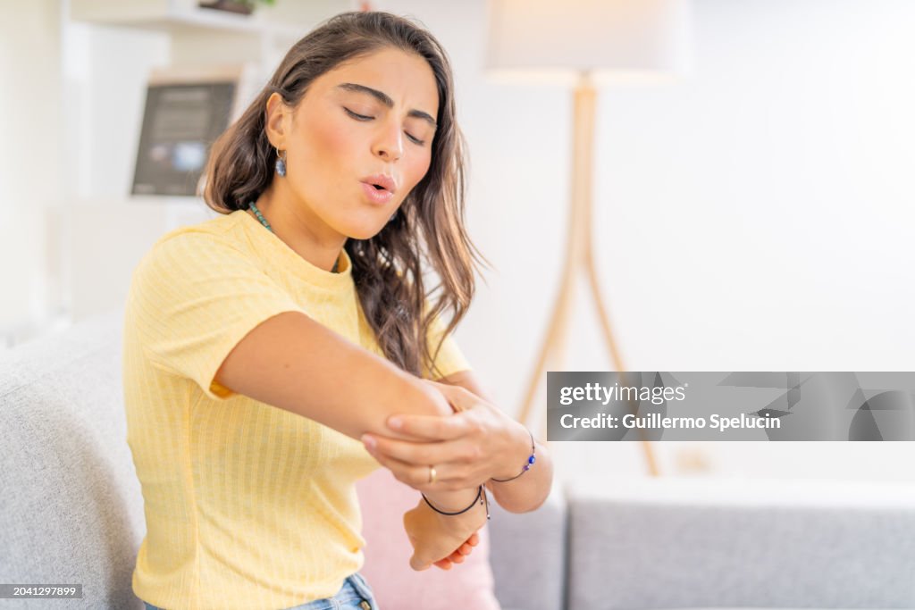 Young woman with elbow pain after hitting herself