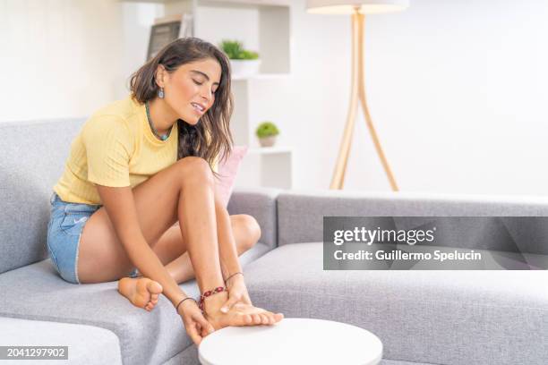 young woman with ankle pain - pé imagens e fotografias de stock