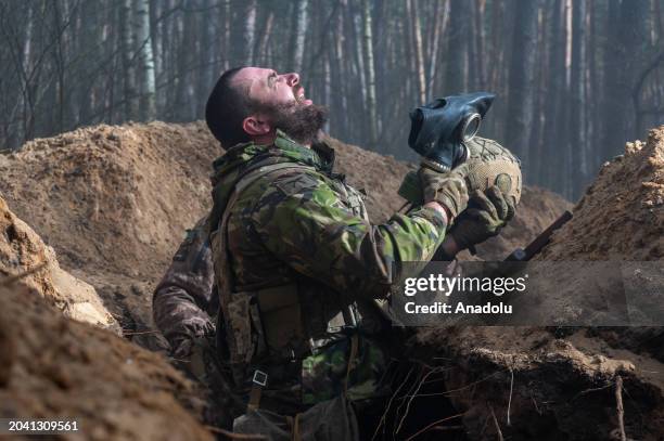 Soldier of the National Guard of Ukraine takes off his gas mask and breathes fresh air after training with simulated smoke as the war between Russia...