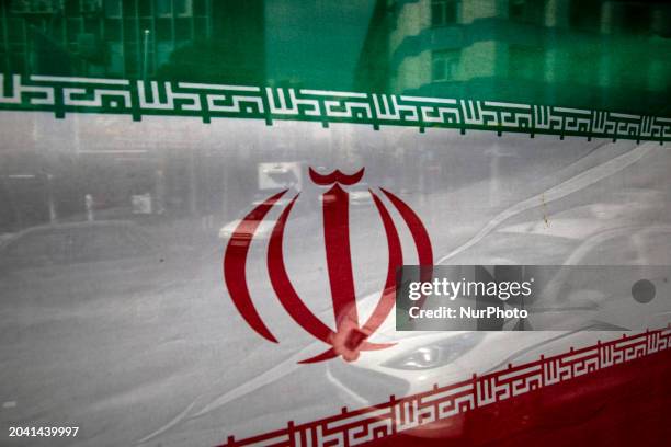 Vehicles are driving past an Iranian flag in downtown Tehran, Iran, on February 28 the day before the Parliamentary and Assembly of Experts...