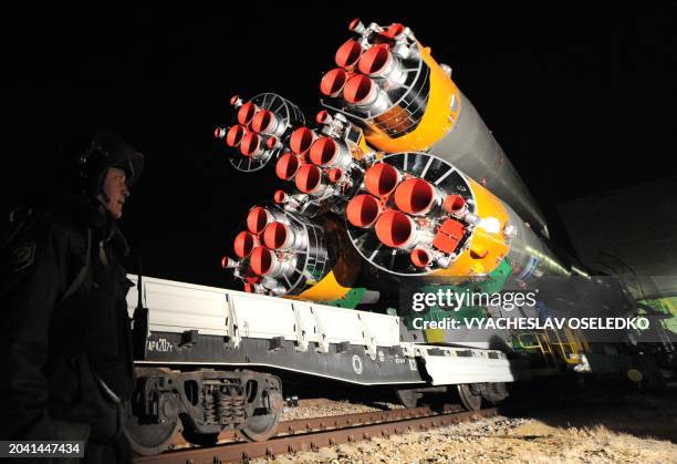 Shaded Russian policeman guards the Soyuz TMA-22 rocket of the International Space Station Expedition 30 during it's transportation to a launch pad...