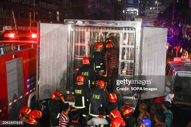 Firefighters carry an injured person during the rescue operations following a fire at a commercial building that killed at least 43 people. At least...