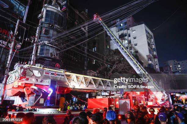 Firefighters use a fire ladder to extract victims during the rescue operations following a fire at a commercial building that killed at least 43...