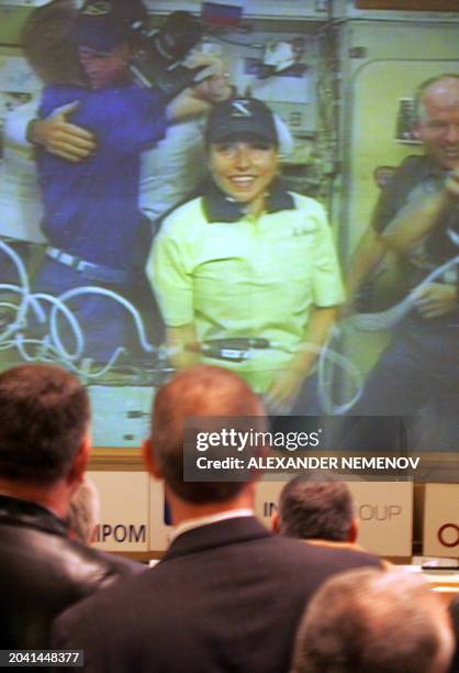 Officials and guests look at the world's first female space tourist Anousheh Ansari on a screen of the Space Mission Control Center in the town of...