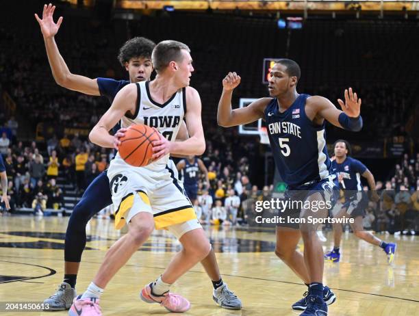 Iowa forward Payton Sandfort holds the ball as Iowa guard Dasonte Bowen defends during a college basketball game between the Penn State Nittany Lions...