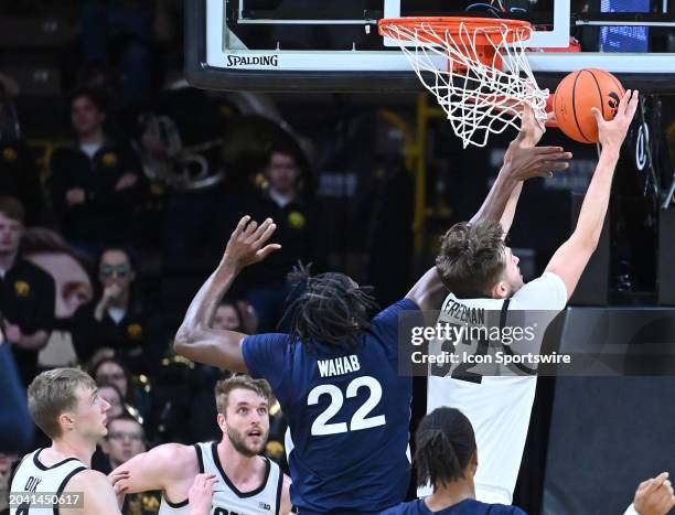 Iowa forward Owen Freeman grabs a rebound over Penn State forward Qudus What during a college basketball game between the Penn State Nittany Lions...