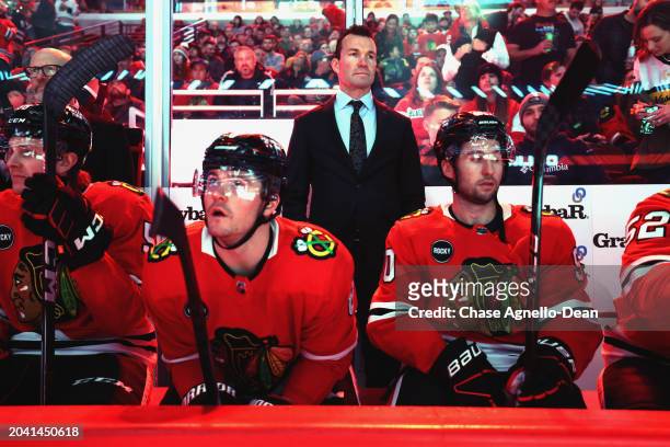 Head coach Luke Richardson of the Chicago Blackhawks stands in the bench behind Ryan Donato and Tyler Johnson during pregame ceremonies against the...