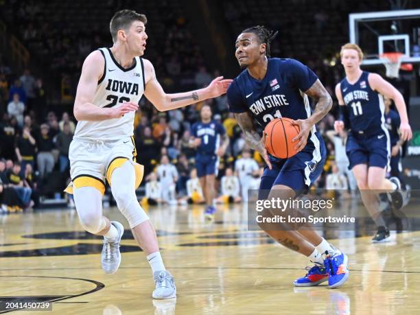 Penn State guard Rayquawndis Mitchell drives to the basket as Iowa forward Patrick McCaffery defends during a college basketball game between the...