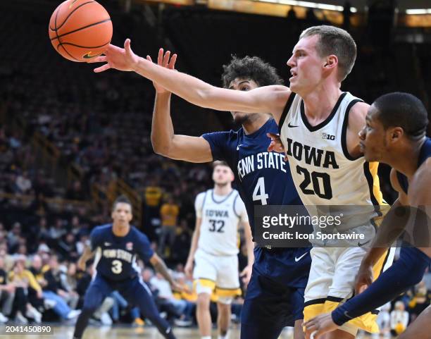 Iowa forward Payton Sandfort passes the ball as Penn State guard Puff Johnson defends during a college basketball game between the Penn State Nittany...