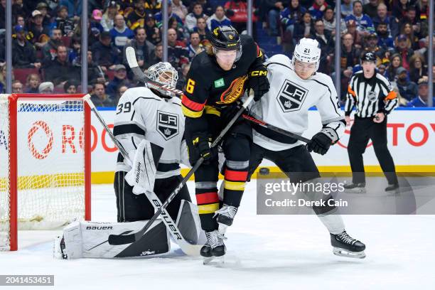 Cam Talbot and Jordan Spence of the Los Angeles Kings defend against Brock Boeser of the Vancouver Canucks during the first period of their NHL game...