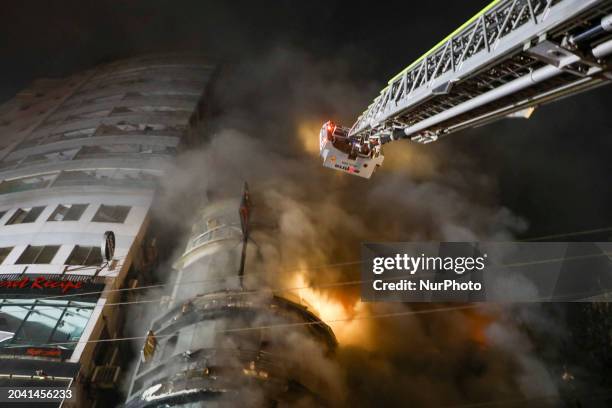 Firefighters are rescuing people from the roof after a fire broke out in a multi-story building in Dhaka, Bangladesh, on February 29, 2024. At least...