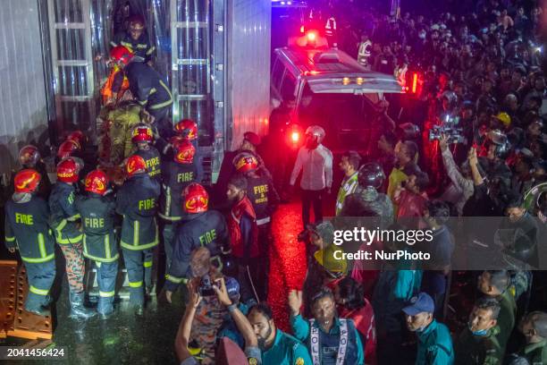 Firefighters are carrying an injured person during a rescue operation after a fire broke out in a commercial building in Dhaka, Bangladesh, on...