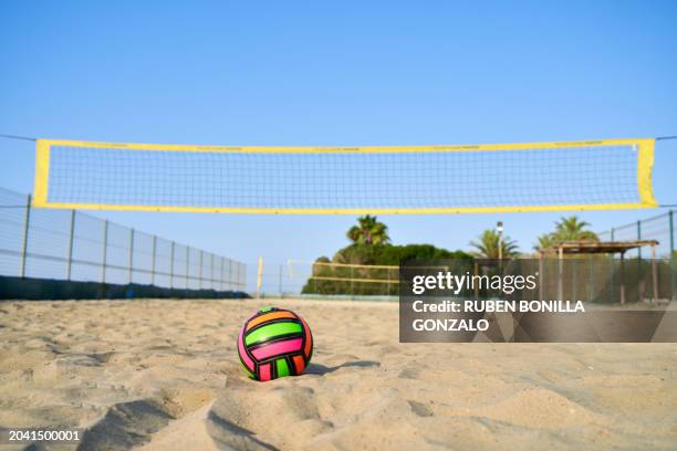 volleyball net on tropical beach with blue sky. no people on sand beach volleyball court with colored ball on the sand. summer sport concept - beach volleyball court stock pictures, royalty-free photos & images